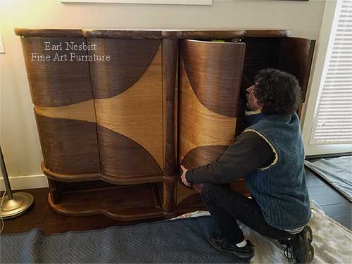 Earl installing retractable doors for custom made art deco cabinet